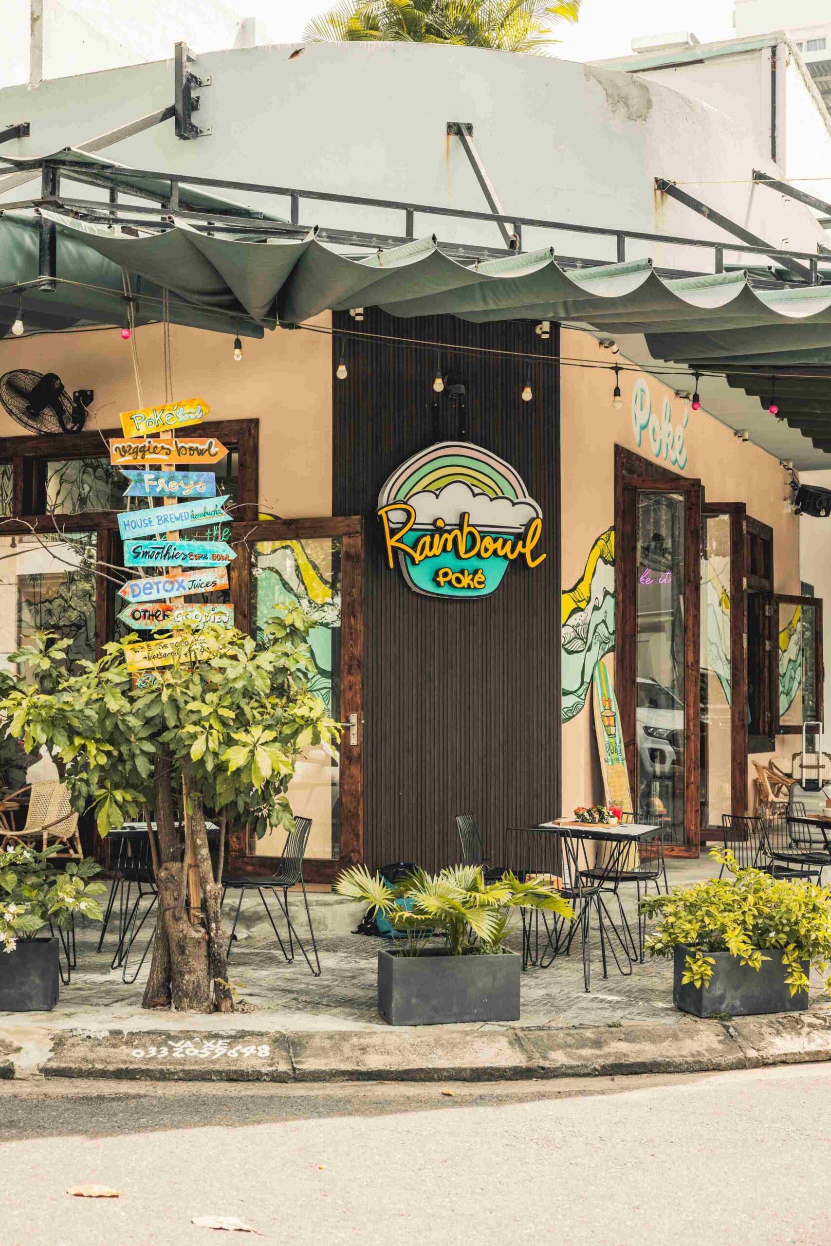 The outside view of Rainbowl Poke restaurant in Da Nang showing outdoor seating and signage