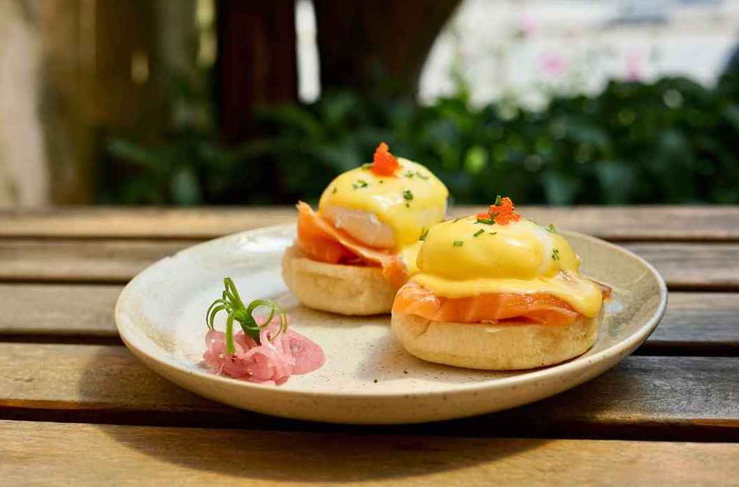 Indulge in our mouthwatering Smoke Salmon Eggs Benedict at Bikini Bottom Da Nang. A delectable dish featuring poached eggs, smoked salmon, and hollandaise sauce on a golden English muffin. Taste the perfection!